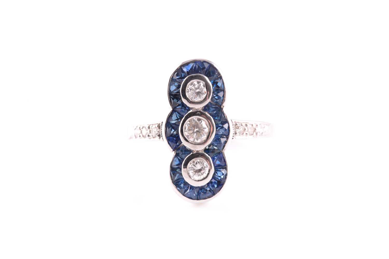 An 18ct white gold, diamond and sapphire ring, in the Art Deco style, the north to south mount inset