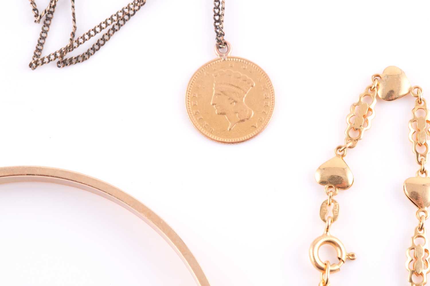 A bangle with textured finish stamped '14k'; an American gold 1 dollarcoin gold with loop surmount - Image 3 of 3