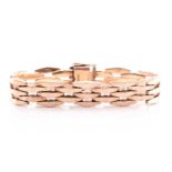 A Cropp and Farr 9 ct gold bracelet with three rows of stylised brick links, the snap catch with