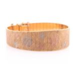 An 18 carat gold bracelet, of slightly tapered panelled form with textured three colour gold panels,