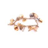 A charm bracelet; the 9 carat gold curb pattern bracelet with padlock clasp; suspending 13 various