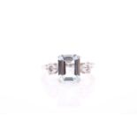 A platinum, diamond, and aquamarine ring, set with a mixed rectangular-cut aquamarine, of