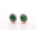 A pair of emerald and diamond cluster earrings, the mixed oval-cut emerald in four claw mount