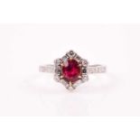 A ruby and diamond cluster ring, the cushion shaped, brilliant step cut ruby in six claw mount,