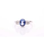 A platinum, diamond, and sapphire ring, set with a mixed oval-cut sapphire, of approximately 1.25