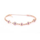 A 15ct yellow gold and amethyst bracelet, set with five target segments each inset with a round-