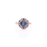 A pale sapphire and diamond cluster ring, the cushion cut sapphire in four double claw setting;