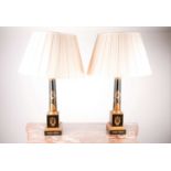 A pair of black toleware Doric column table lamps. Decorated with gilt neoclassical decoration, on a