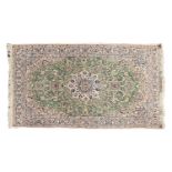 A 20th-century pistachio green ground Nain rug. With central boss and corner decoration with a