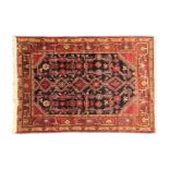 A 20th century dark blue ground Hamadan rug. With hooked lozenges and geometric motifs, within