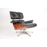 After Charles and Ray Eames, a revolving lounge chair in black hide and laminated palisander.