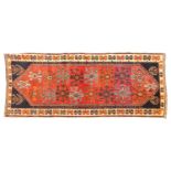 A 20th-century tomato red ground Qashqai rug with an all-over geometric design. Within an ivory