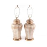 A pair of gilt pottery table lamps of bold reeded baluster form each supported on simple socle
