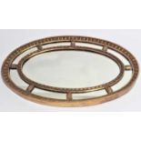 A George III style oval gilt framed wall mirror. With moulded and beaded border. 82 cm long x 52