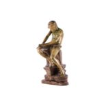 A Goldscheider terracotta figure of a young Arab boy whittling a stick with a knife. Seated on a
