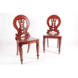 A pair of Victorian mahogany hall chairs. With pieced hoop backs solid seats and turned fore