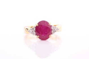 A yellow metal, diamond, and ruby ring, set with a mixed oval-cut ruby flanked with six round-cut