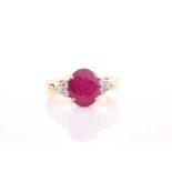 A yellow metal, diamond, and ruby ring, set with a mixed oval-cut ruby flanked with six round-cut