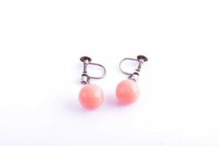 A pair of diamond and coral drop earrings, each suspended with a rounded coral bead, approximately