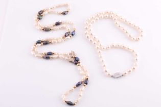 A white and black 'rice krispie' pearl necklace, fastened with a small yellow metal bow-shaped