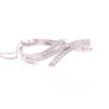 A diamond bangle of crossover design, inset with graduated round brilliant-cut diamonds of