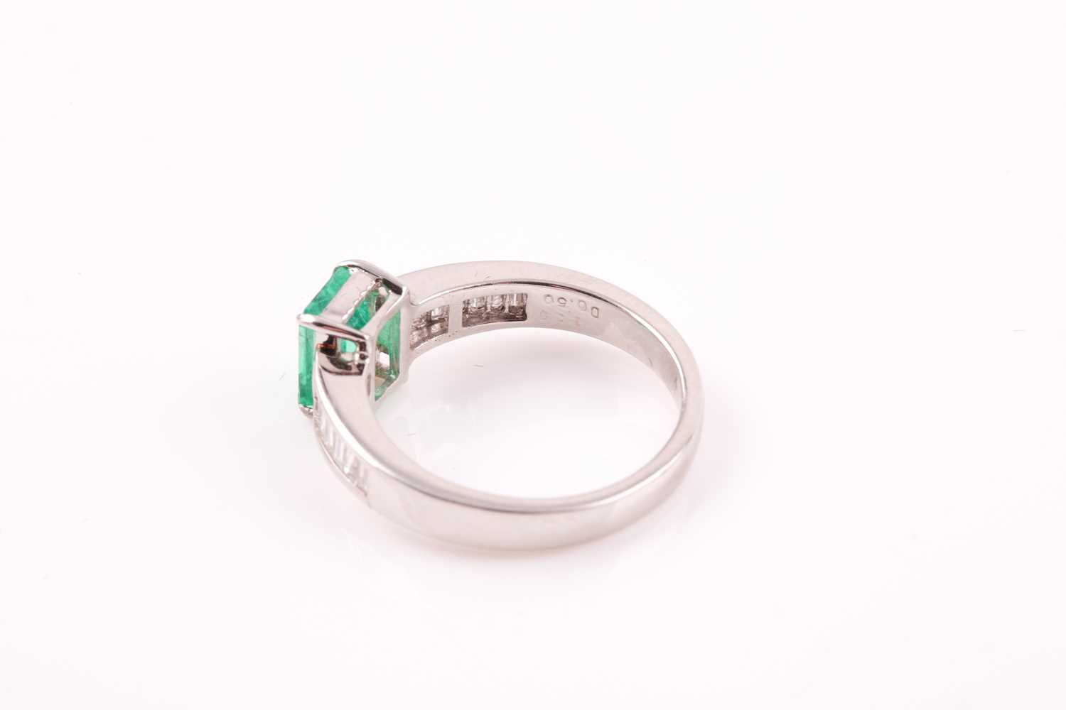 An emerald and diamond ring; the rectanguar, cut cornered, step cut emerald in four claw mount, to - Image 2 of 5