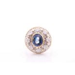 An unusual diamond and sapphire cluster ring, of bombe design, centred with a mixed oval-cut