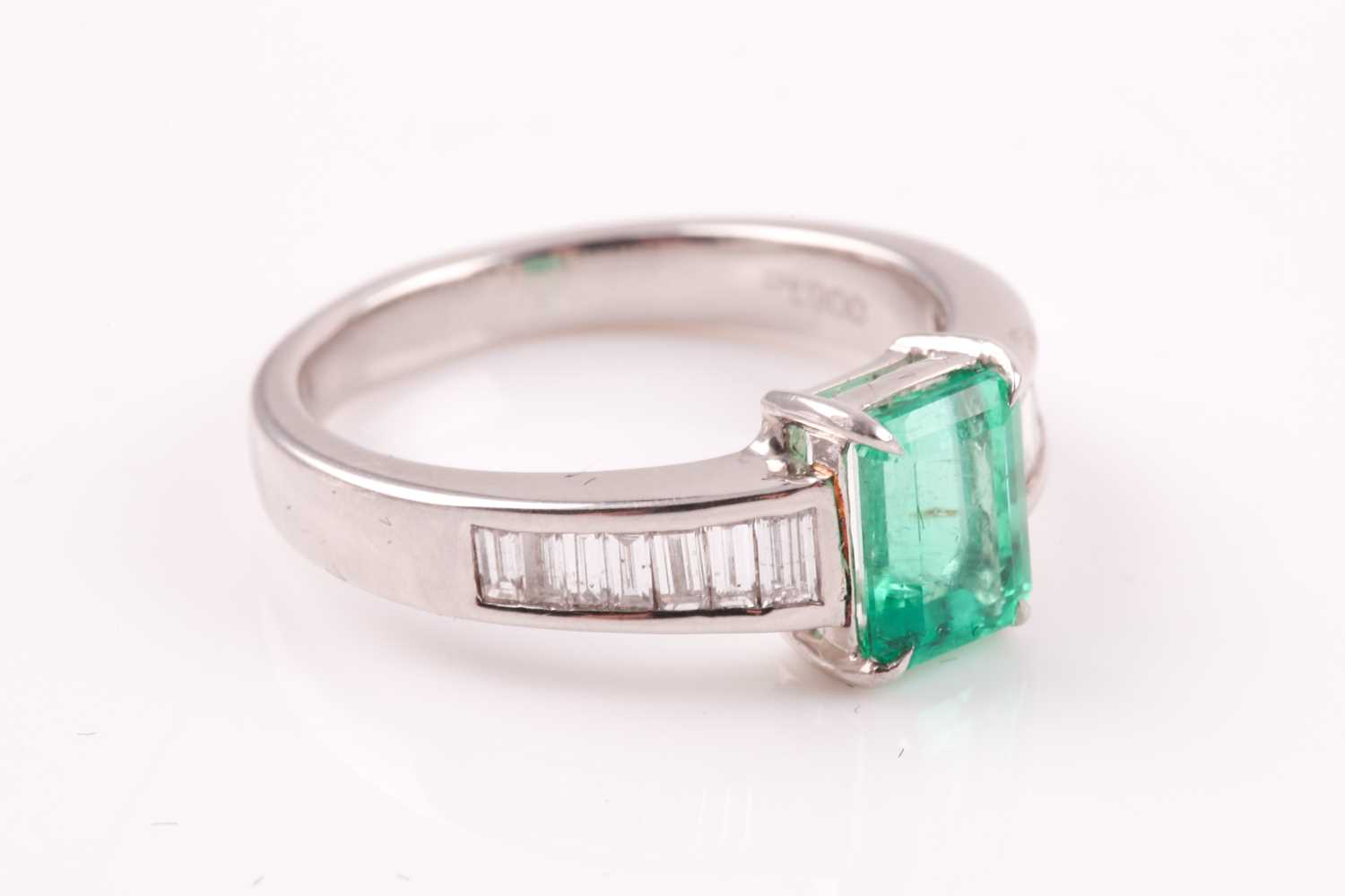 An emerald and diamond ring; the rectanguar, cut cornered, step cut emerald in four claw mount, to - Image 4 of 5