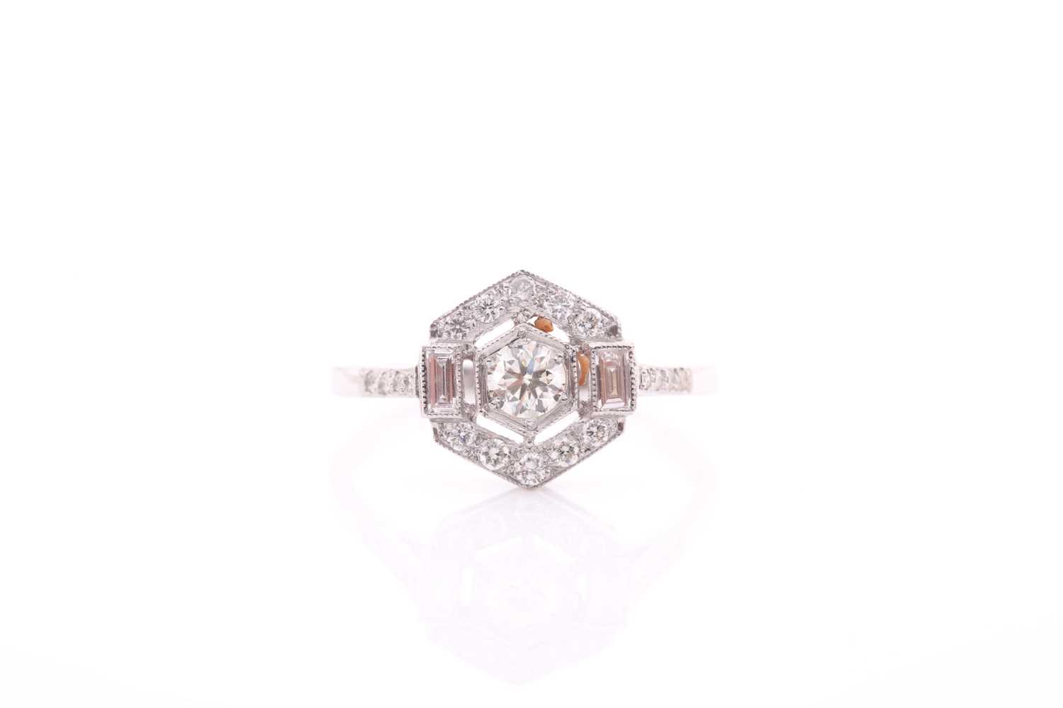 A platinum and diamond ring of hexagonal design, centred with a round brilliant-cut diamond within a