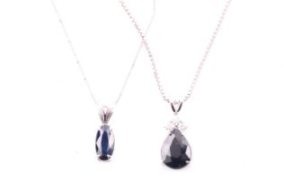 A white metal and sapphire pendant set with a pear-cut dark blue sapphire, on a silver chain,