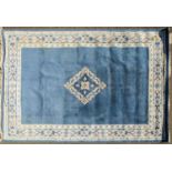 A modern powder blue Chinese sculpted and washed carpet with central diamond lozenge, and a floral