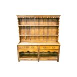 A 19th century stripped pine two drawer pot board dresser and rack, with shaped apron and square