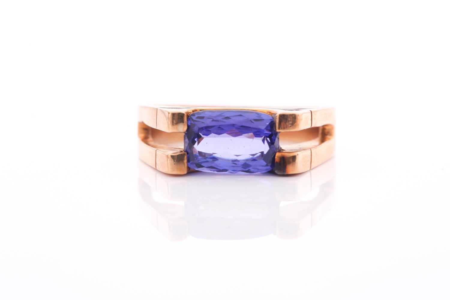 An 18ct yellow gold and tanzanite ring, set east to west with a rectangular mixed-cut tanzanite,