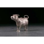 A George III silver cow creamer. London 1764 by John Schuppe. The animal standing four square with