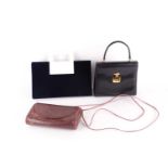 A Gucci black leather handbag, of plain tapering rectangular form and red leather interior,