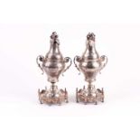 A pair of Middle Eastern white metal baluster vases, with dome covers and ornate bases, 24 cms high,
