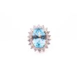 An 18ct yellow gold, diamond, and blue topaz cocktail ring, set with a mixed oval-cut topaz of