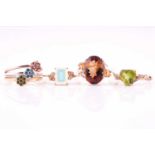 Four gem set rings, two set in 9 carat gold, one with heart-shaped peridot and diamond set
