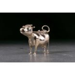 A George III silver cow creamer. London 1764 by John Schuppe. The animal standing four square with