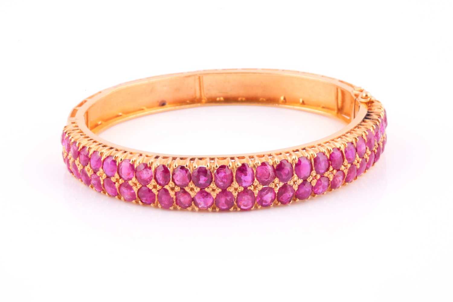 A ruby bangle; composed of two rows of mixed oval cut rubies in carved claw mounts to a foliate - Image 3 of 4