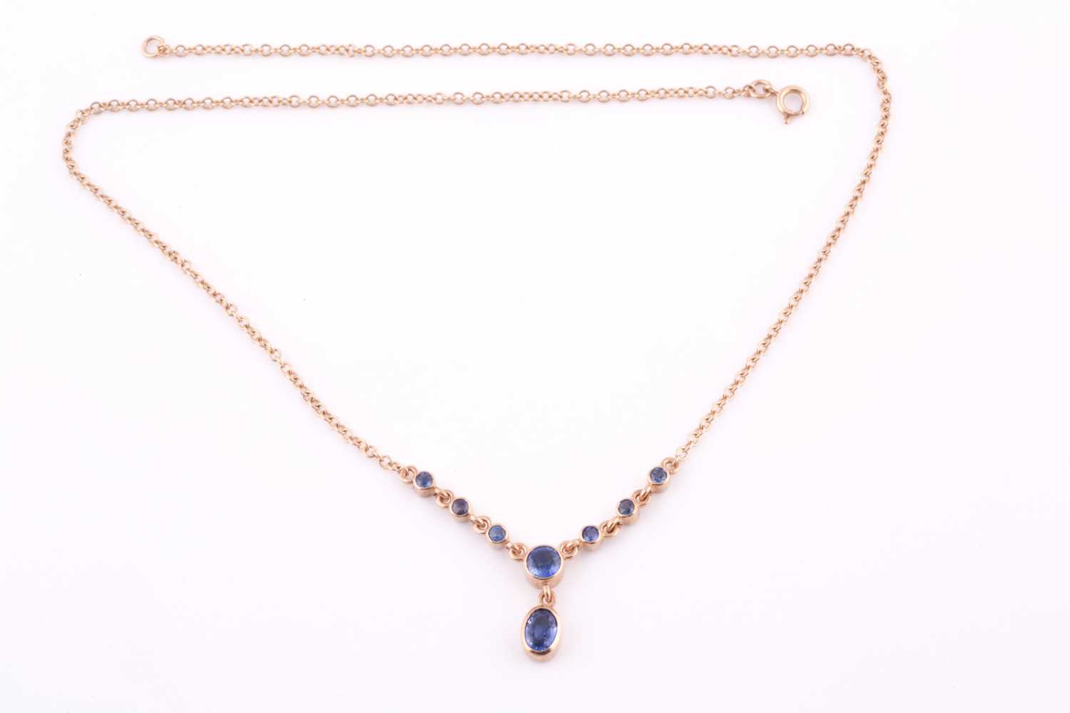 A 9ct yellow gold and blue sapphire drop pendant necklace, set with a mixed oval-cut sapphire - Image 3 of 4