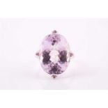 A kunzite and pink sapphire cocktail ring, set with a large mixed oval-cut pale lilac kunzite,
