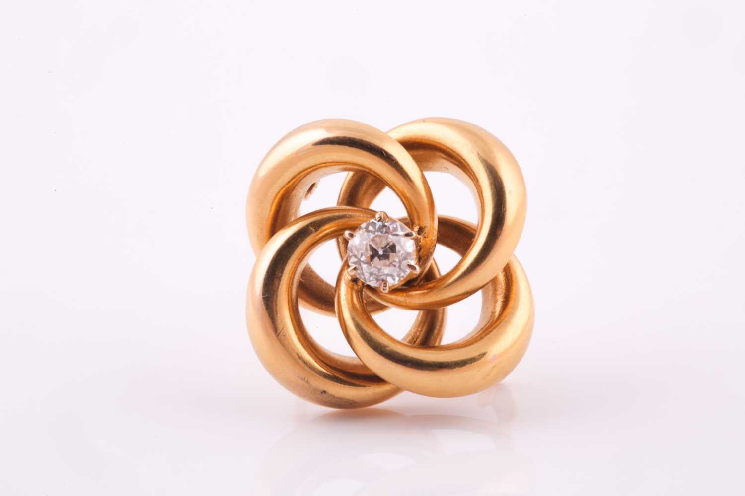 A lovers knot brooch, in yellow metal with central claw set old cut diamond, 4.9 mm diameter,