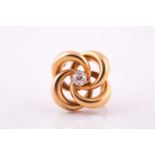 A lovers knot brooch, in yellow metal with central claw set old cut diamond, 4.9 mm diameter,
