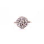A platinum and diamond daisy cluster ring, set with seven old-cut diamonds, approximate colour I-
