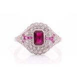 An Art Deco diamond and ruby ring, inset with a rectangular-cut ruby, the surrounding mount set with