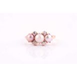 A yellow metal, diamond, and pearl ring, set with a white pearl and two pale pink pearls, likely