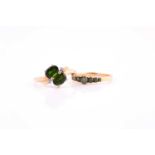 A two stone chrome diopside cross-over ring with three stone diamond detail to shoulders in 9