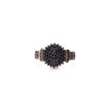 A black diamond cluster ring; the bombé style circular centre set with multiple circular cut