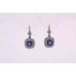 A pair of diamond and sapphire drop earrings, each set with a cushion-cut blue sapphire within a